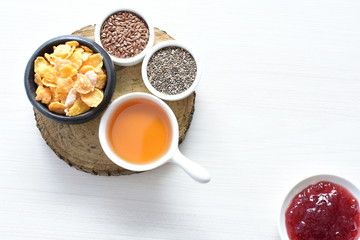 Cereal flakes without sugar, accompanied by seeds, jam and honey