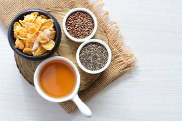 Cereal flakes without sugar, accompanied by seeds, jam and honey