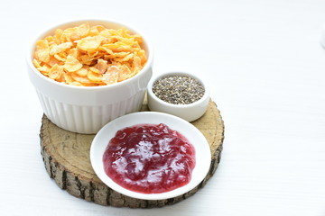 Cereal flakes without sugar, accompanied by seeds, jam and honey