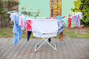 Clotheshorse on cortis. Drying rack with loundry on the garth. Rack dryer with clothes on backyard,...