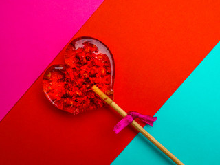 Single heart-shaped lollipop of valentines day on colorful background