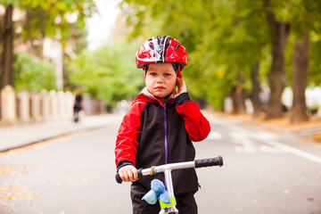 Obraz premium Girl in safety helmet riding a balance bike