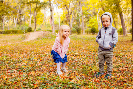 Cute Little Twins Boy And Girl Playing Together In Autumn Park