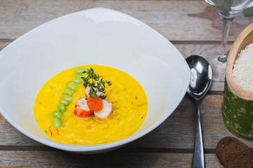 Traditional rice with seafood, risotto with rice and shrimp in a deep white plate on a table in a restaurant.