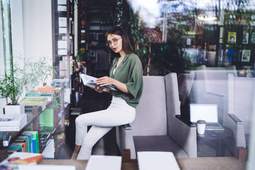 Fototapeta premium Young lady relaxing in cozy library