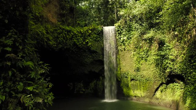 Aerial drone flight in cave of Air Terjun Tibumana waterfall, Bali, Indonesia, 4k