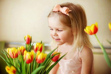 a girl looks at flowers, a bouquet of tulips , spring has come