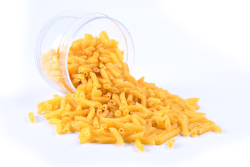 Glass jar filled with dry rotini yellow pasta over isolated white background