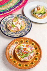 Mexican ham toast also called tostadas with beans and cheese on white background