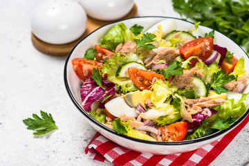 Tuna salad with green leaves, eggs and vegetables.