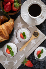 Natural yogurt with chia seeds and strawberries on a gray background. Breakfast chia seeds pudding with coconut milk and strawberries