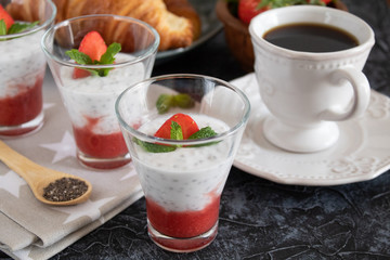Natural yogurt with chia seeds and strawberries on a gray background. Breakfast chia seeds pudding with coconut milk and strawberries