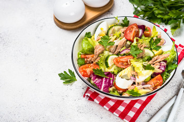 Tuna salad with green leaves, eggs and vegetables.
