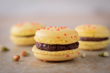 Lemon Yellow Macaron Cookies with Chocolate Filling on Tile Counter