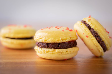 Lemon Macaron Cookies with Chocolate Filling on Wood Counter