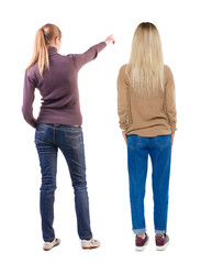 Back view of two pointing young girl in sweater.