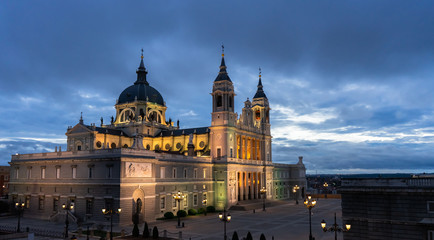 Night view of the Saint Mary the Royal of La Almudena Cathedral in Madrid on a cloudy day without people.