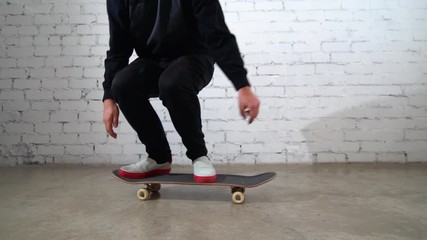 Skateboarder performing skateboard trick - ollie on concrete. Athlete practicing jump, preparing for competition. Extreme sport, youth culture, urban style