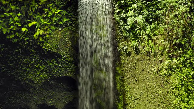 Aerial drone flight in the direction of water of Air Terjun Tibumana waterfall, Bali, Indonesia, 4k