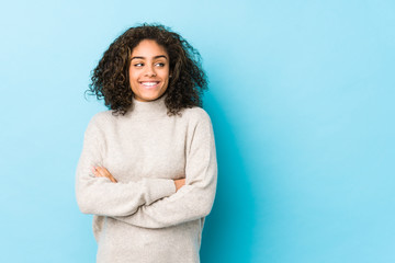 Fototapeta premium Young african american curly hair woman smiling confident with crossed arms.