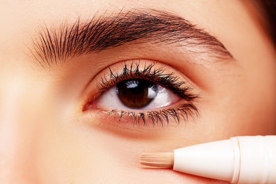 Skin tone. Eye corrector. Natural make up for eyes close up. Model face of beautiful woman with foundation on skin make-up cosmetics. Perfect skin tone. Apply concealer and cosmetic highlighter.