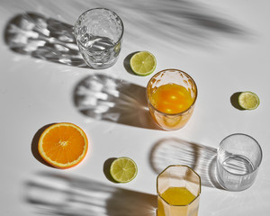 glass with orange juice.  Sun hard light shadow reflection. Tropical summer minimalism concept