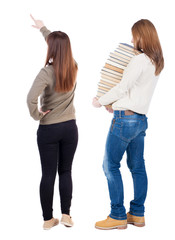 Back view of two pointing young girl in sweater.