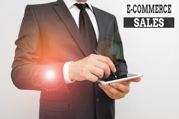 Conceptual hand writing showing E Commerce Sales. Concept meaning activity of buying or selling of products on online service Male human wear formal work suit hold smartphone using hand