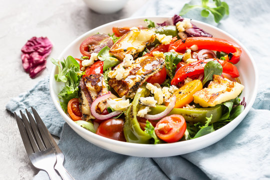 Vegetable Salad Cherry Tomatoes, Baked Pepper, Salad Mix And Onion With Grilled Haloumi (halloumi) Cheese. Keto Diet, Healthy Food. Light Grey Stone Background. Close Up.