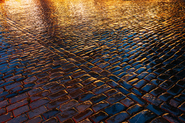Old Streets Cobblestone Abstract Background. Wet Stones In Evening Or Night Illuminations. Travel Abstract Background