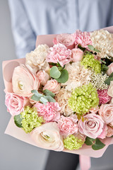 European floral shop. Beautiful bouquet of mixed flowers in womans hands. the work of the florist at a flower shop. Delivery fresh cut flower.