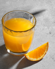 glass with orange juice.  Sun hard light shadow reflection. Tropical summer minimalism concept