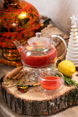 Hot fruit red berry tea with steam in the teapot with mint, berries, lemon slices on wooden background. Food and drink. New year holidays, christmas xmas dinner concept