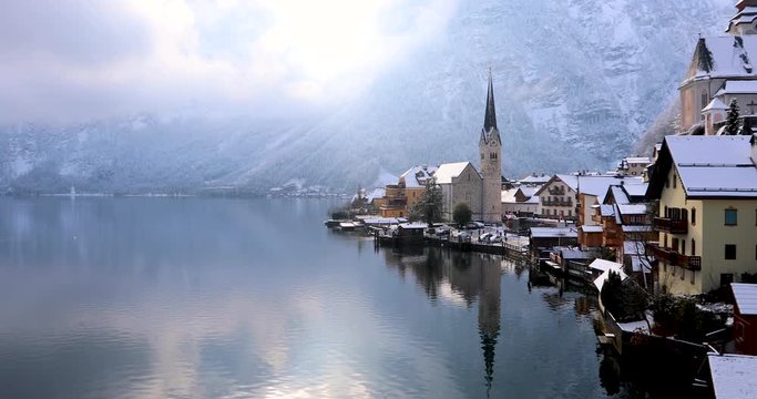 Ein sonniger Wintertag &uuml;ber dem Dorf Hallstatt, Alpen, &Ouml;sterreich, mit Schnee und Wolken