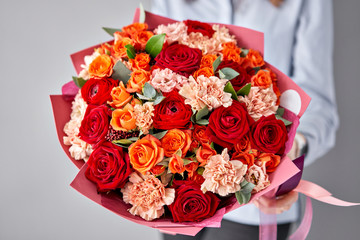 European floral shop. Beautiful bouquet of mixed flowers in womans hands. the work of the florist at a flower shop. Delivery fresh cut flower.