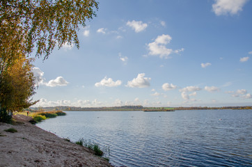 autumn landscape. stand and look into the distance standing on the shore of the lake. think about life and the infinity of being. the clouds float across the sky slightly reflecting in the water.