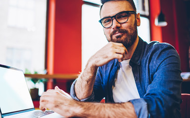 Content businessman in casual wear using blank screen laptop at cafe