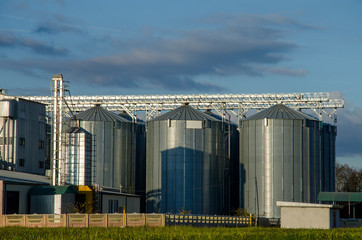 A large modern plant for the storage and processing of grain crops. view of the granary on a sunny day against the blue sky. End of harvest season.