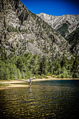 Fototapeta premium Woman fly fishing in alpine lake