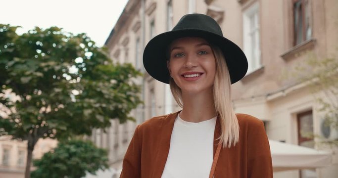 Portrait of Beautiful Blonde girl having a Walk in the Town, Wearing Stylish clothes. Posing on Camera and looking Pleasant. Pretty woman with stylish Black Hat and gorgeous look.
