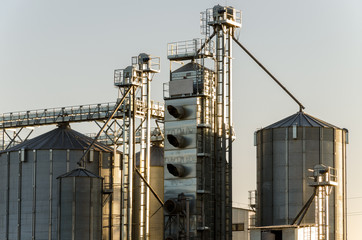 A large modern plant for the storage and processing of grain crops. view of the granary on a sunny day against the blue sky. End of harvest season.