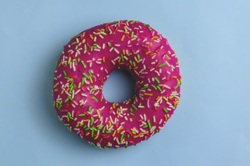 Tasty pink donut on color background
