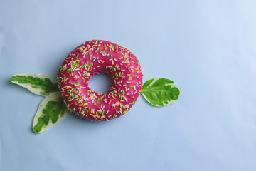 Tasty pink donut on color background
