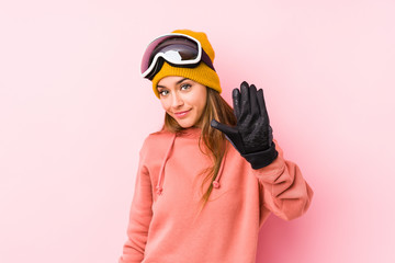 Young caucasian woman wearing a ski clothes isolated smiling cheerful showing number five with fingers.