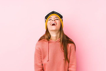Young caucasian woman wearing a ski clothes isolated relaxed and happy laughing, neck stretched showing teeth.