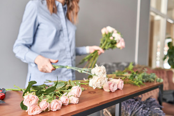 Obraz na płótnie Canvas Floral shop concept . Florist woman creates flower arrangement. Beautiful bouquet of mixed flowers. Handsome fresh bunch. Flowers delivery.