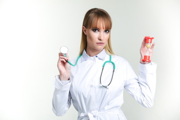 woman doctor holds hourglass on gray background