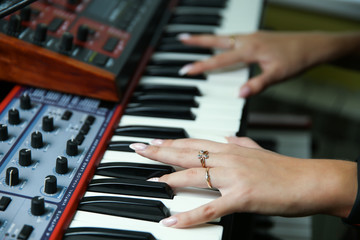 Obraz premium hands of a woman play a synthesizer close up