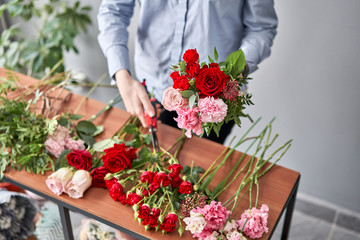Woman florist creating beautiful bouquet in flower shop. Work in flower shop. Flowers delivery.