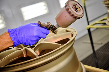 man working in factory. Design and tuning disc of the car.